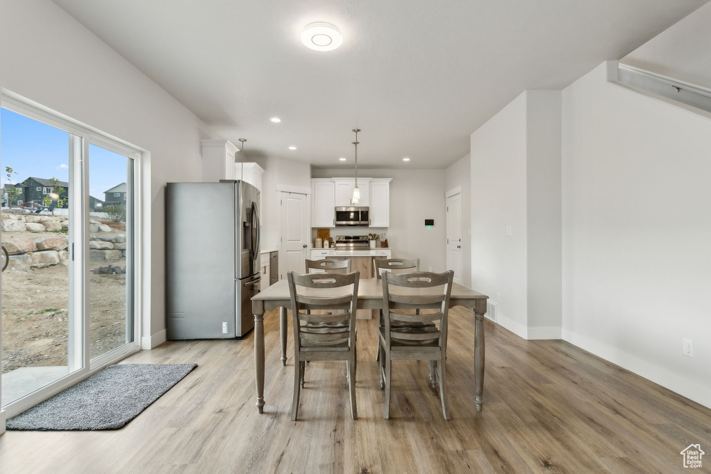 Dining room featuring light wood-style floors, baseboards, and recessed lighting