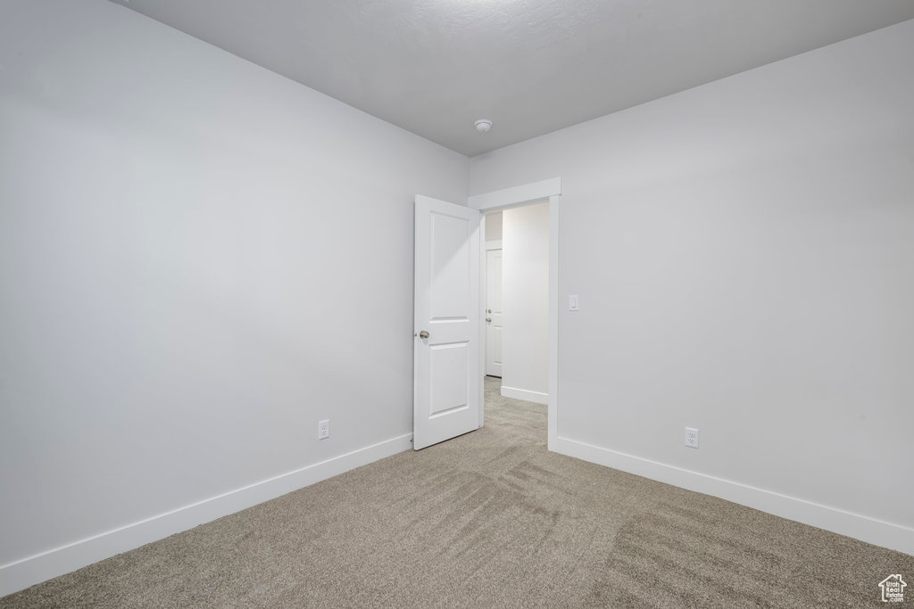 Spare room featuring carpet and baseboards