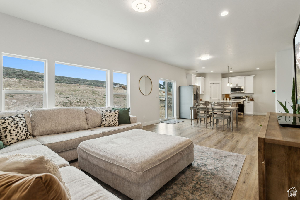 Living room with light wood-style flooring, baseboards, and recessed lighting