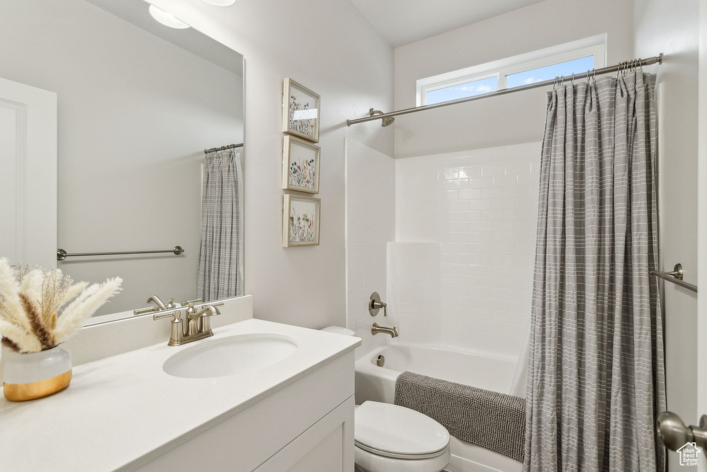 Full bath featuring shower / tub combo, toilet, and vanity