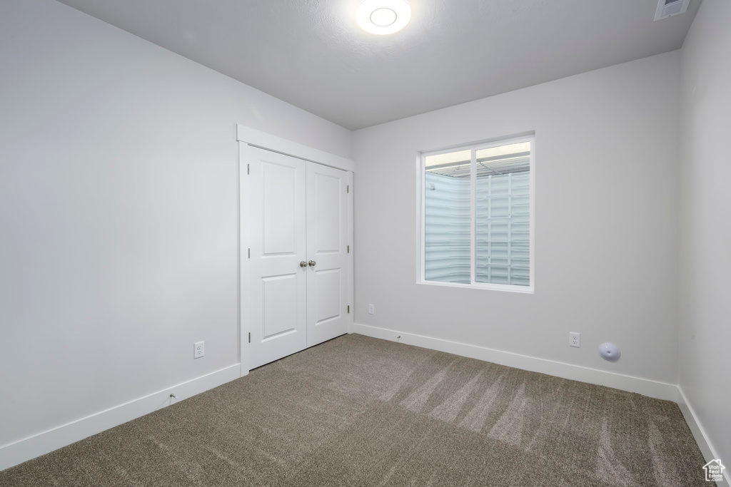 Unfurnished bedroom featuring carpet floors and baseboards
