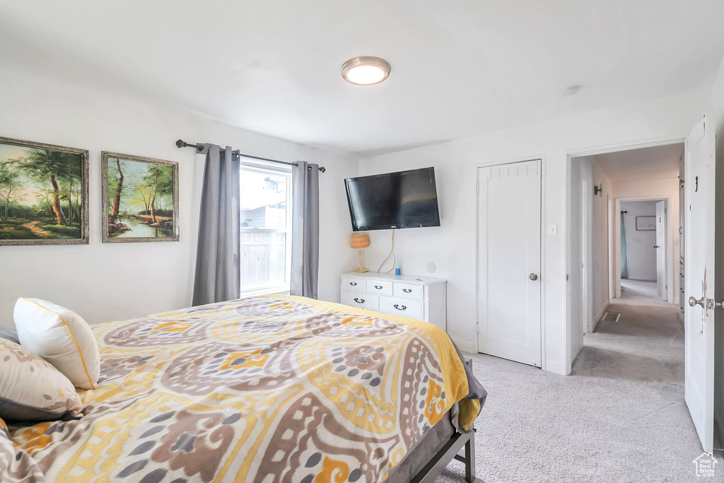 Bedroom with light colored carpet and a closet