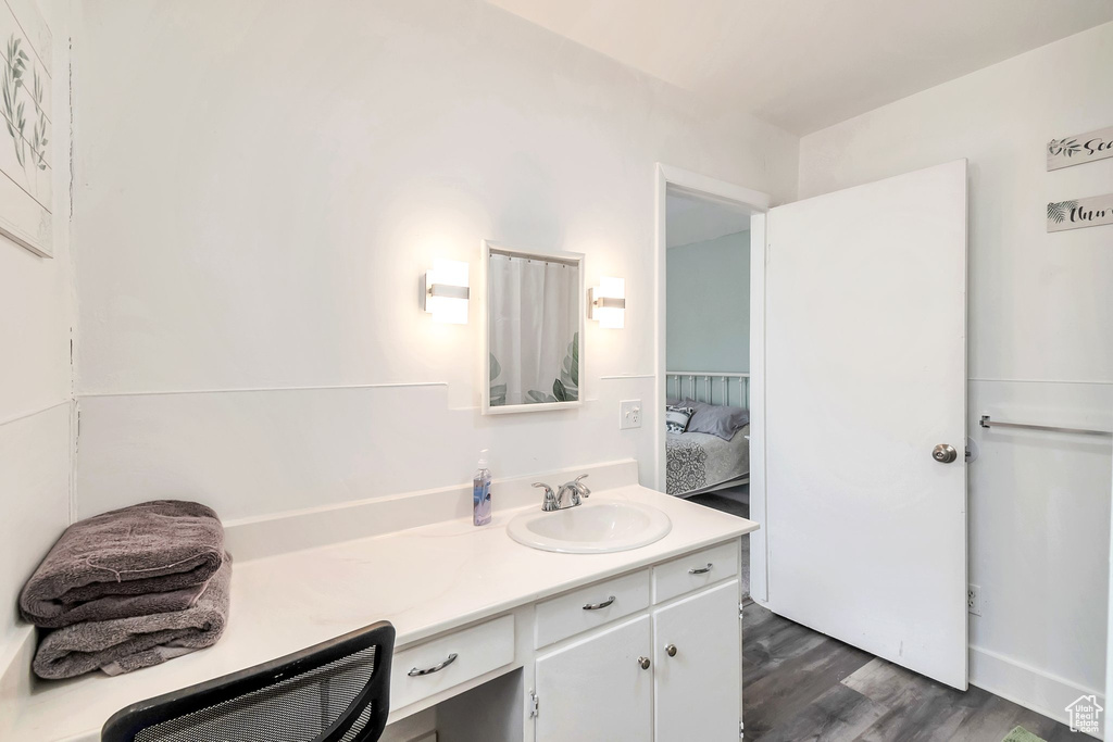 Bathroom with vanity, connected bathroom, and wood finished floors