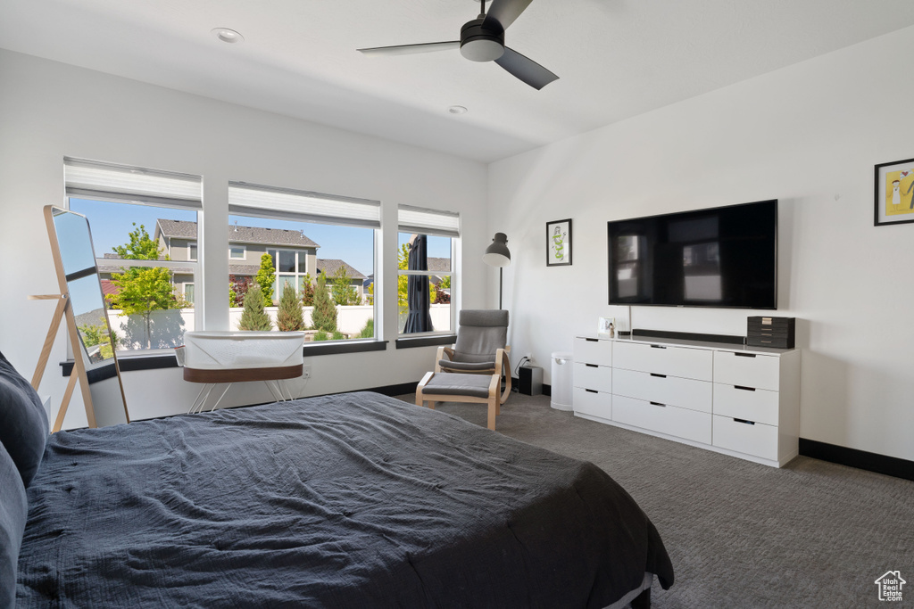 Carpeted bedroom featuring baseboards and ceiling fan