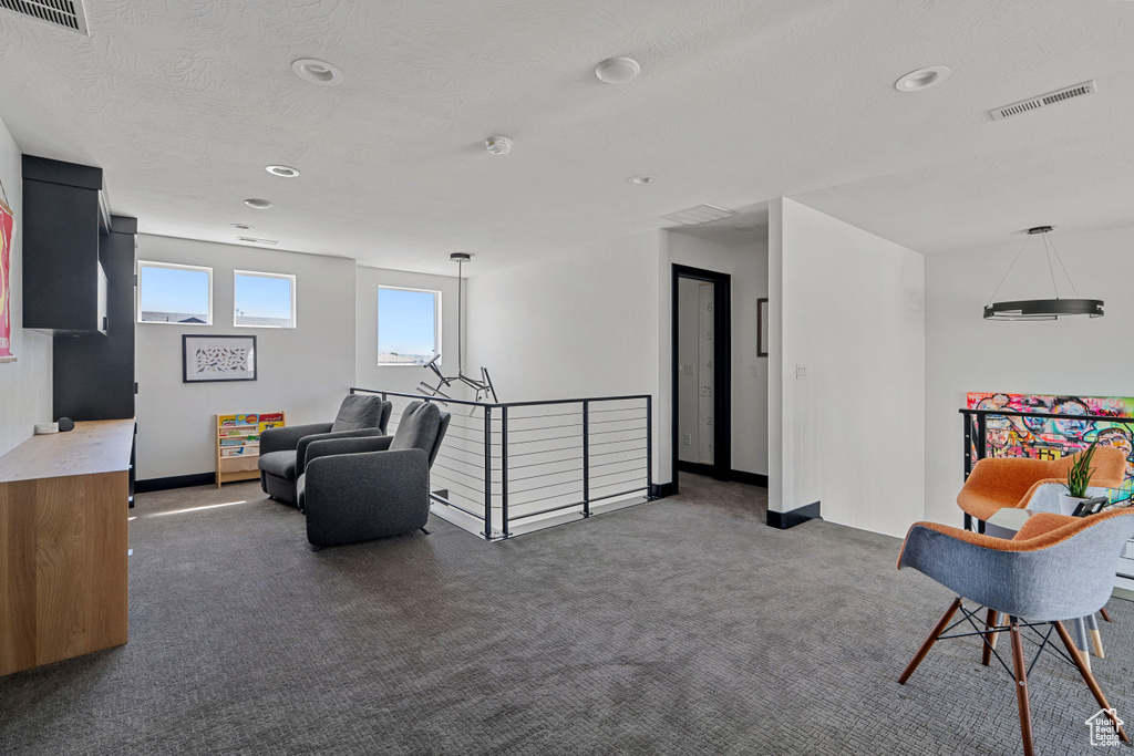 Living area with carpet, an upstairs landing, baseboards, and recessed lighting