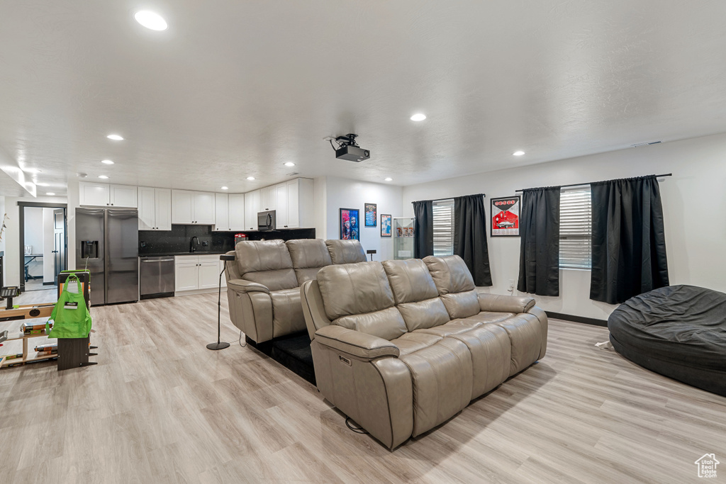 Cinema featuring recessed lighting, a sink, and light wood-style flooring