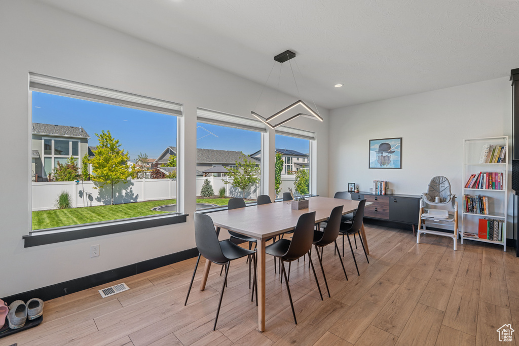 Dining room with light wood-type flooring and recessed lighting