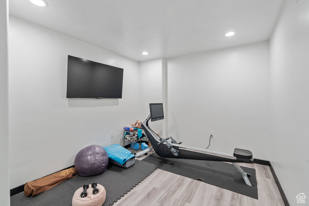 Exercise room featuring wood finished floors, recessed lighting, and baseboards