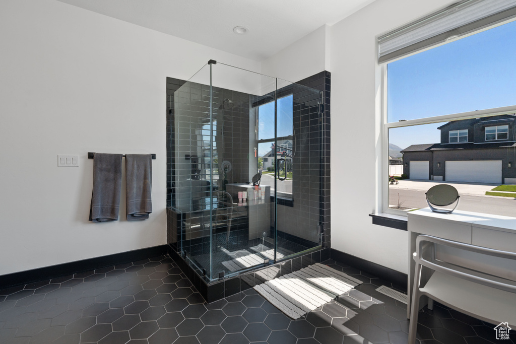 Full bath with plenty of natural light, tile patterned flooring, a shower stall, and baseboards