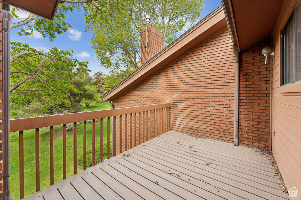 Wooden terrace featuring a yard