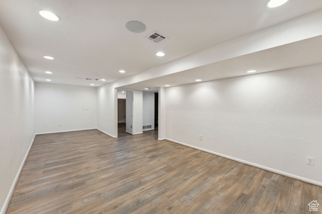 Finished below grade area with baseboards, wood finished floors, and recessed lighting