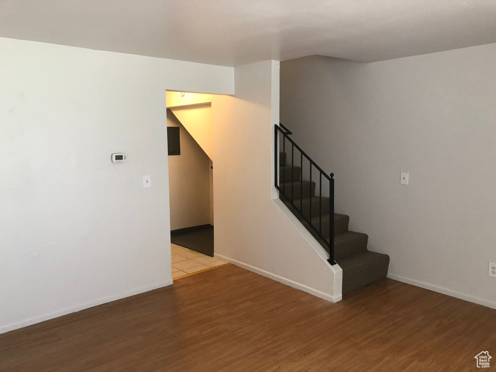 Stairway with wood finished floors and baseboards