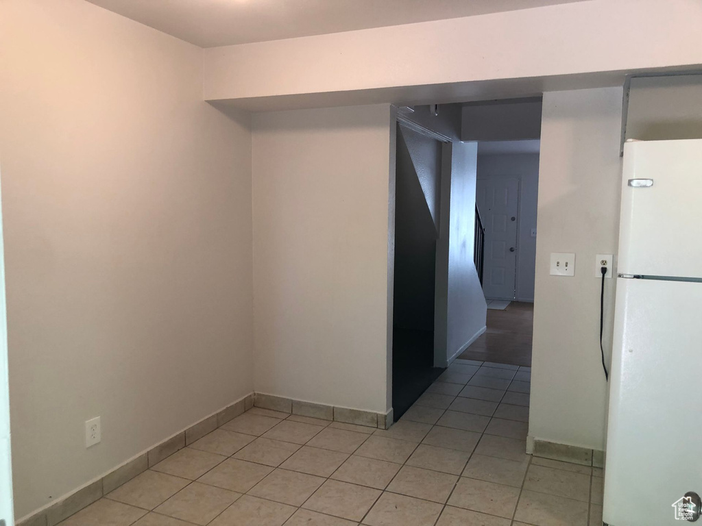 Unfurnished room with light tile patterned floors and baseboards