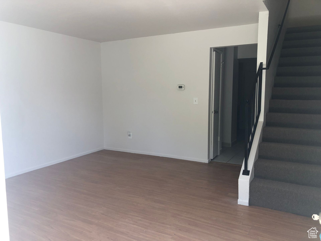 Unfurnished room with wood finished floors, stairs, and baseboards