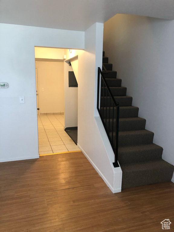 Stairs with wood finished floors and baseboards