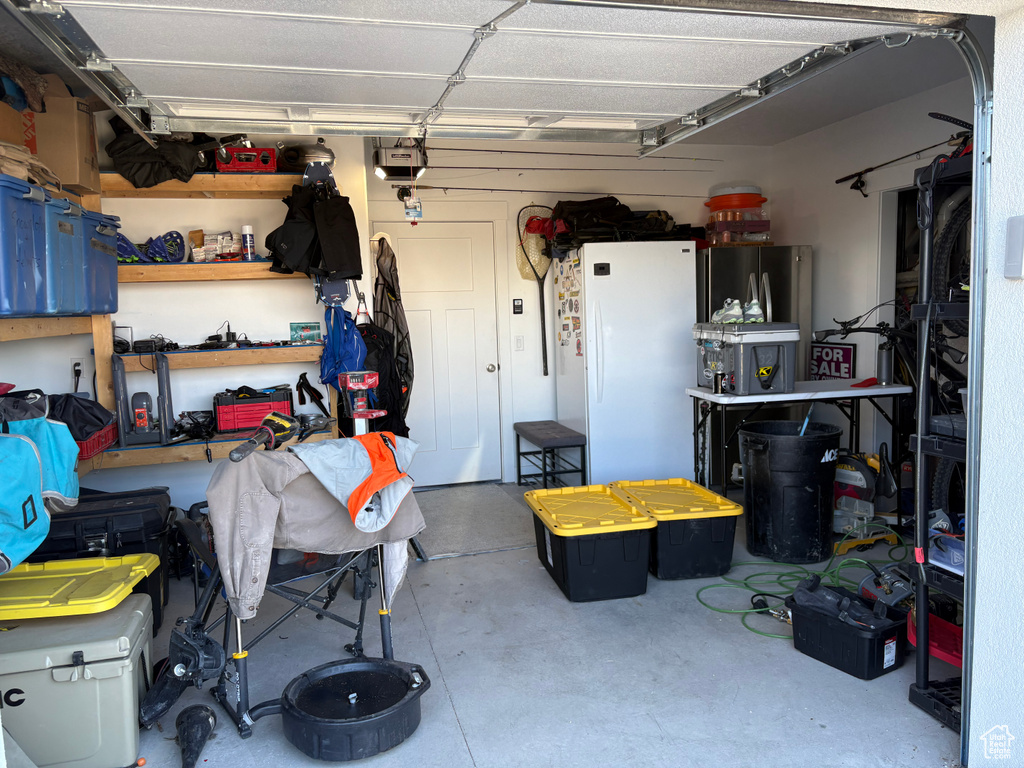 Garage featuring freestanding refrigerator and a garage door opener