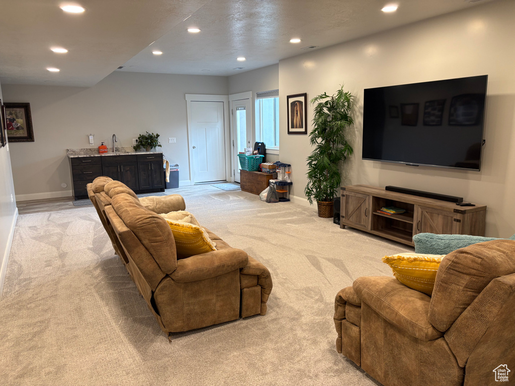 Living room featuring light colored carpet, recessed lighting, and baseboards