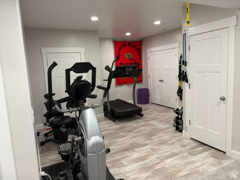 Exercise room with light wood finished floors, recessed lighting, and baseboards