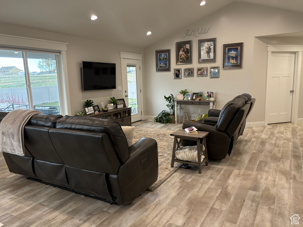 Living room with light wood-style flooring, recessed lighting, lofted ceiling, plenty of natural light, and baseboards