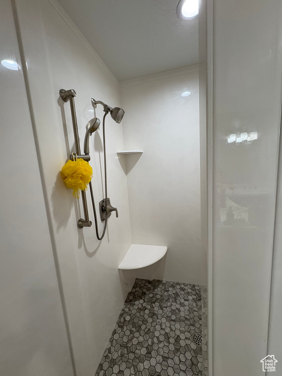 Bathroom with tiled shower and tile patterned floors