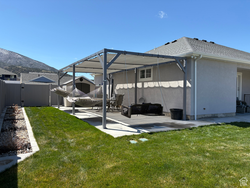 Rear view of house with a patio, stucco siding, and a mountain view