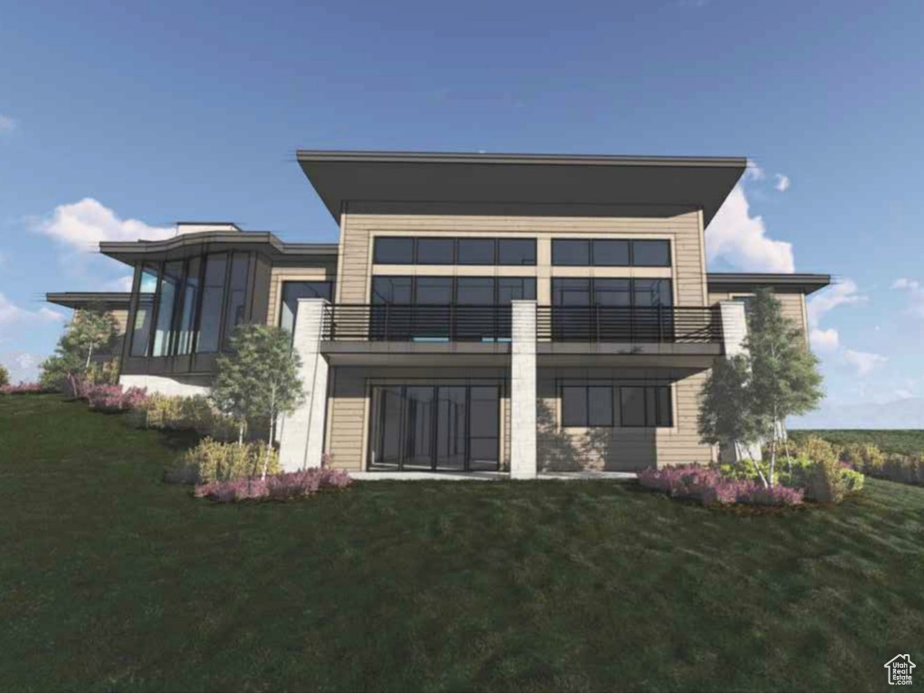 Back of house featuring a balcony and a lawn