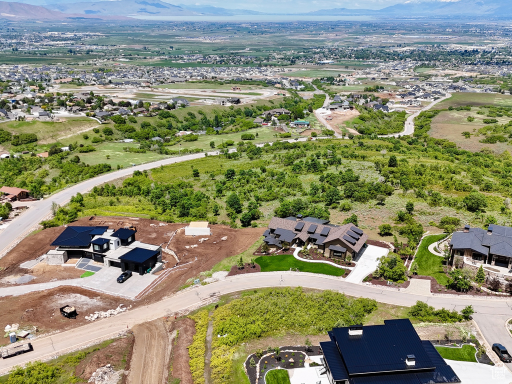 Aerial view of property and surrounding area with a mountain backdrop and nearby suburban area