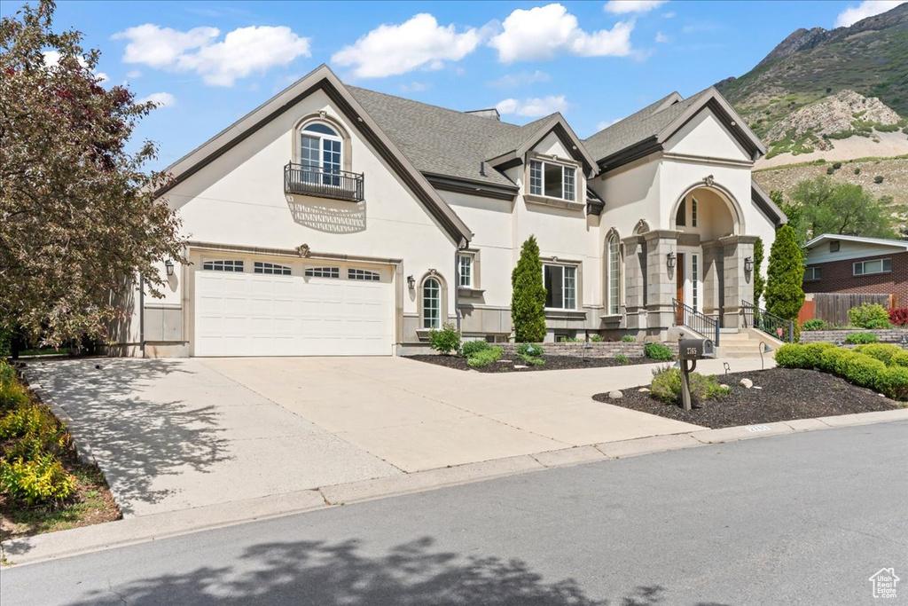 View of front facade featuring concrete driveway, stucco siding, and a mountain view
