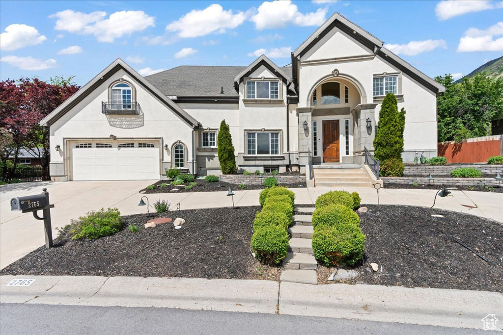 French country style house featuring stucco siding, driveway, and an attached garage