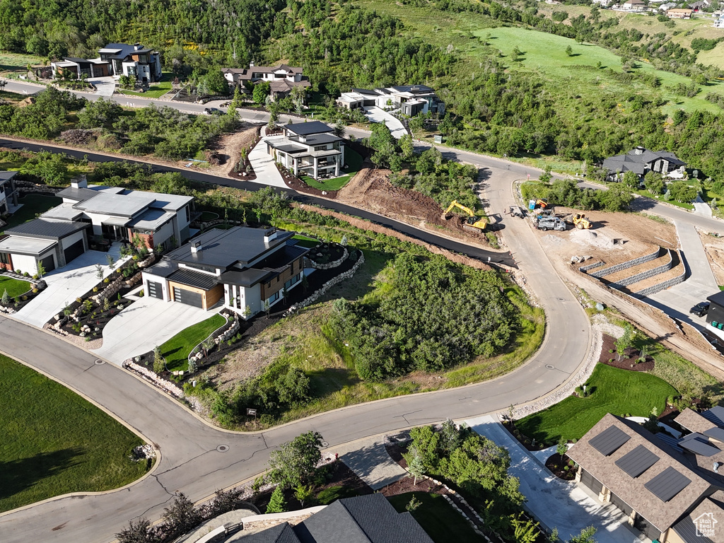 Aerial overview of property's location featuring nearby suburban area and a heavily wooded area