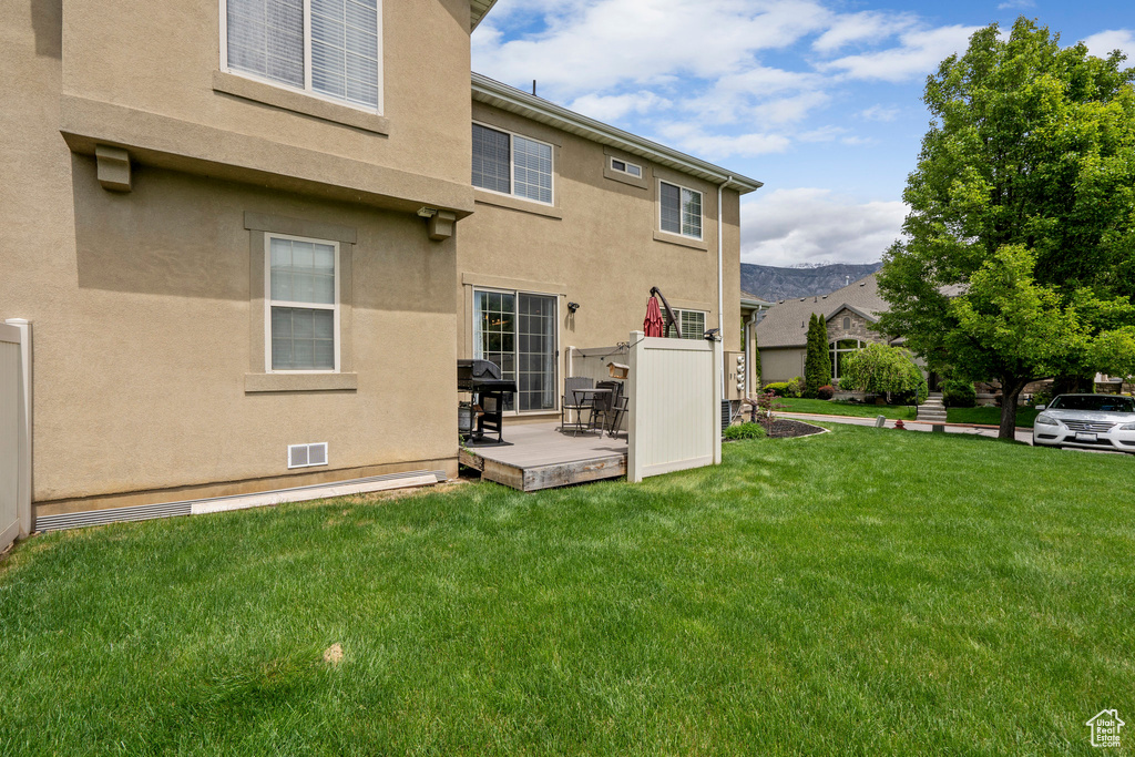 Back of house with stucco siding and a lawn