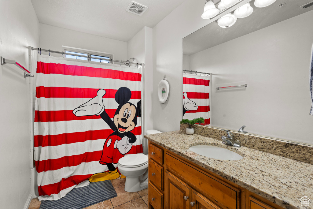 Full bath with tile patterned flooring, vanity, toilet, and a shower with curtain