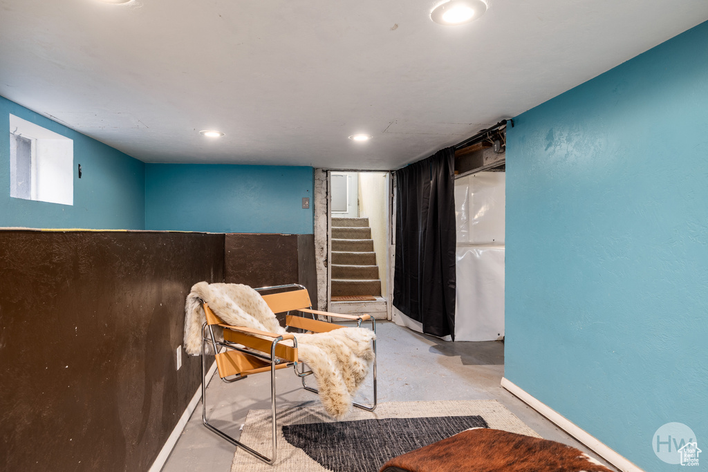 Sitting room with concrete flooring and stairway