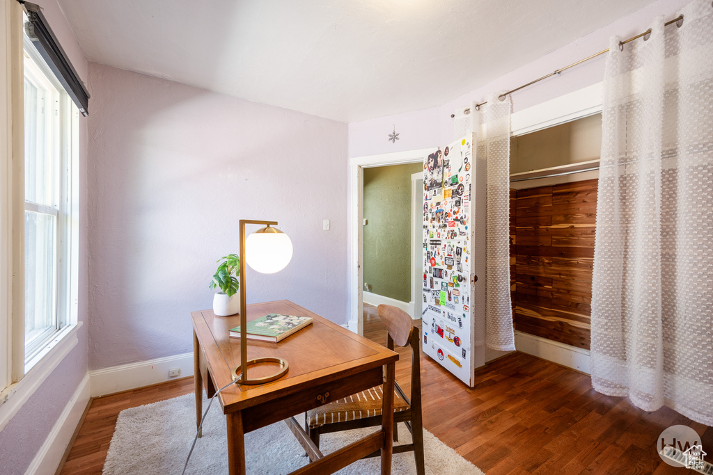 Dining space with wood finished floors, plenty of natural light, and a desk