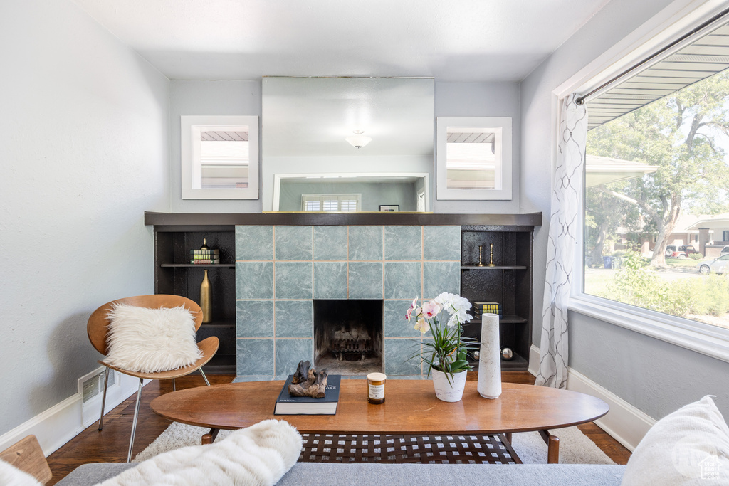 Living room with wood finished floors, a fireplace, and healthy amount of natural light