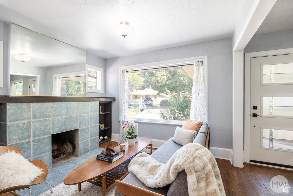 Living room with wood finished floors and a tile fireplace
