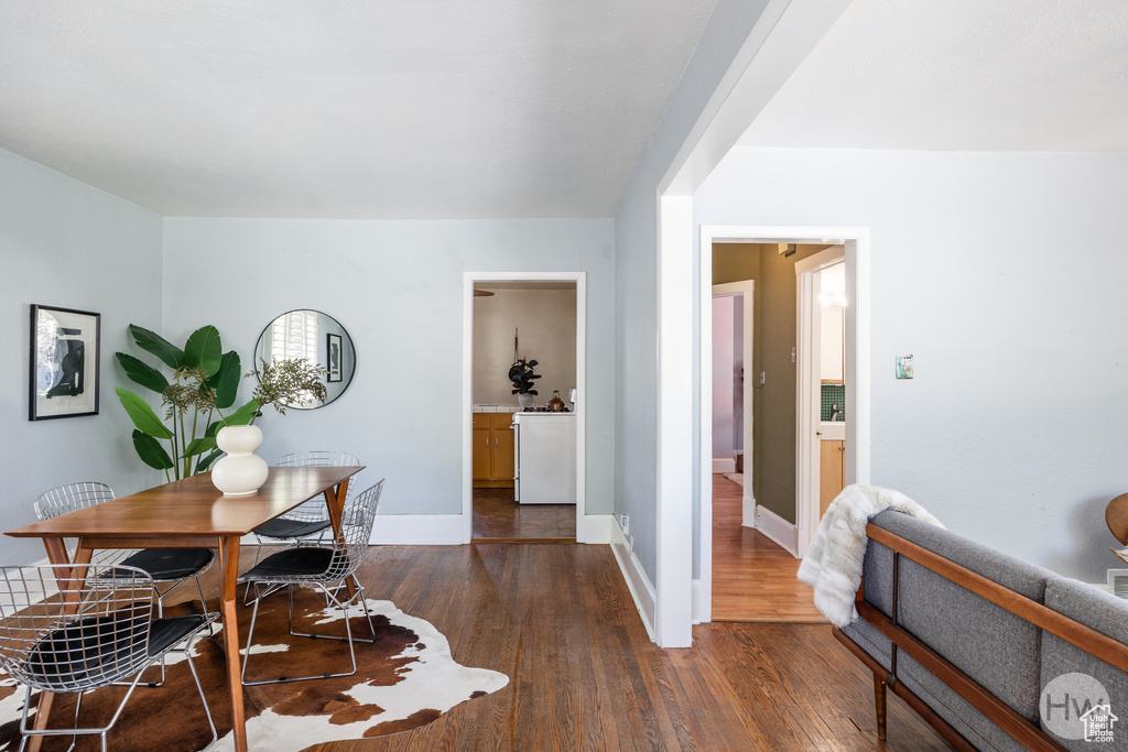 Dining room with dark wood-style floors and baseboards