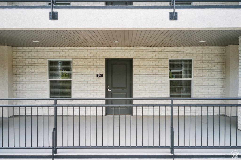 View of exterior entry with brick siding and a balcony