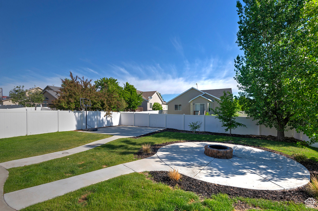 View of yard with an outdoor fire pit and a patio