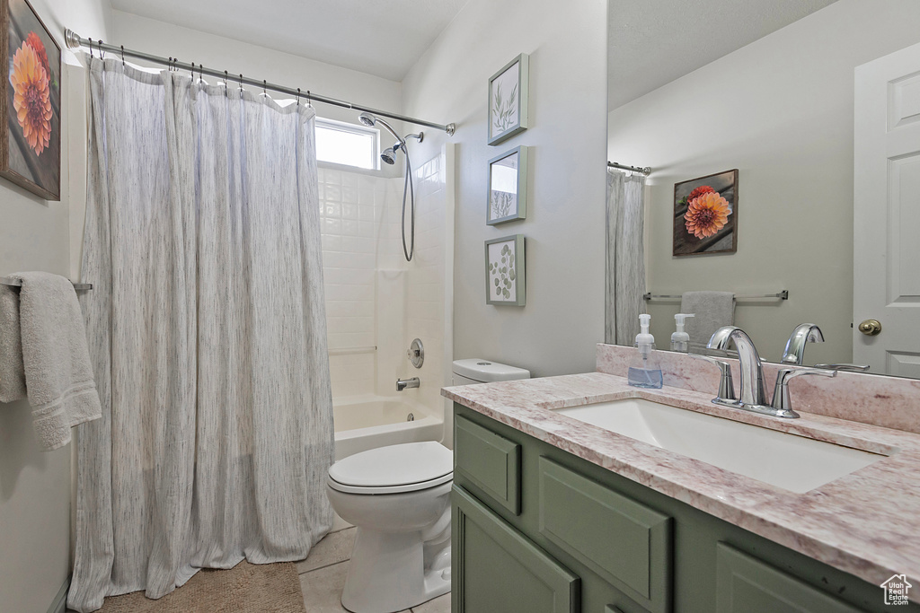 Bathroom featuring toilet, vanity, shower / tub combo with curtain, and tile patterned floors