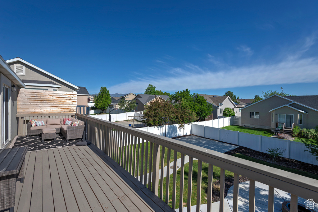 Wooden deck with a residential view, an outdoor living space, and a fenced backyard