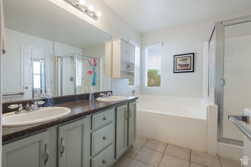 Full bathroom featuring tile patterned floors, a stall shower, a bath, and double vanity