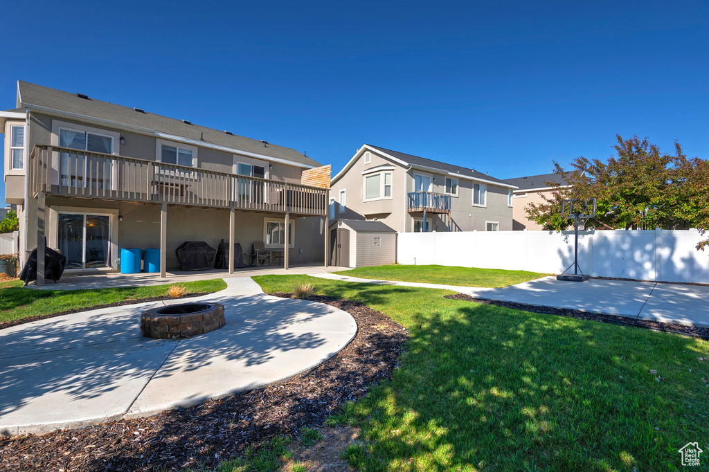 Back of house featuring a fire pit, a patio, stucco siding, a deck, and a residential view