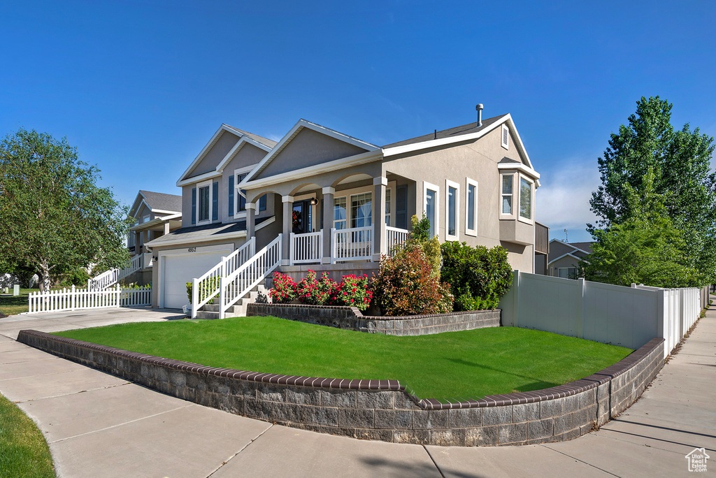 View of front of home featuring covered porch, a garage, stucco siding, and driveway