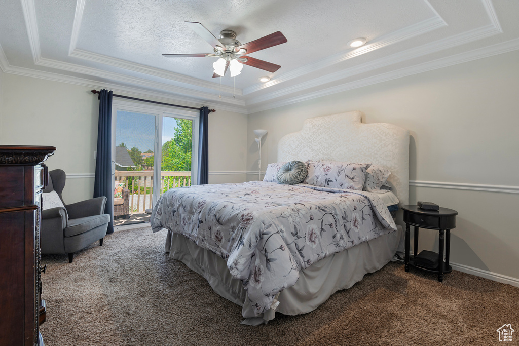 Carpeted bedroom with a raised ceiling, crown molding, access to outside, ceiling fan, and baseboards