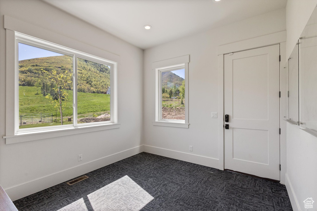 Entryway featuring dark carpet, recessed lighting, and baseboards
