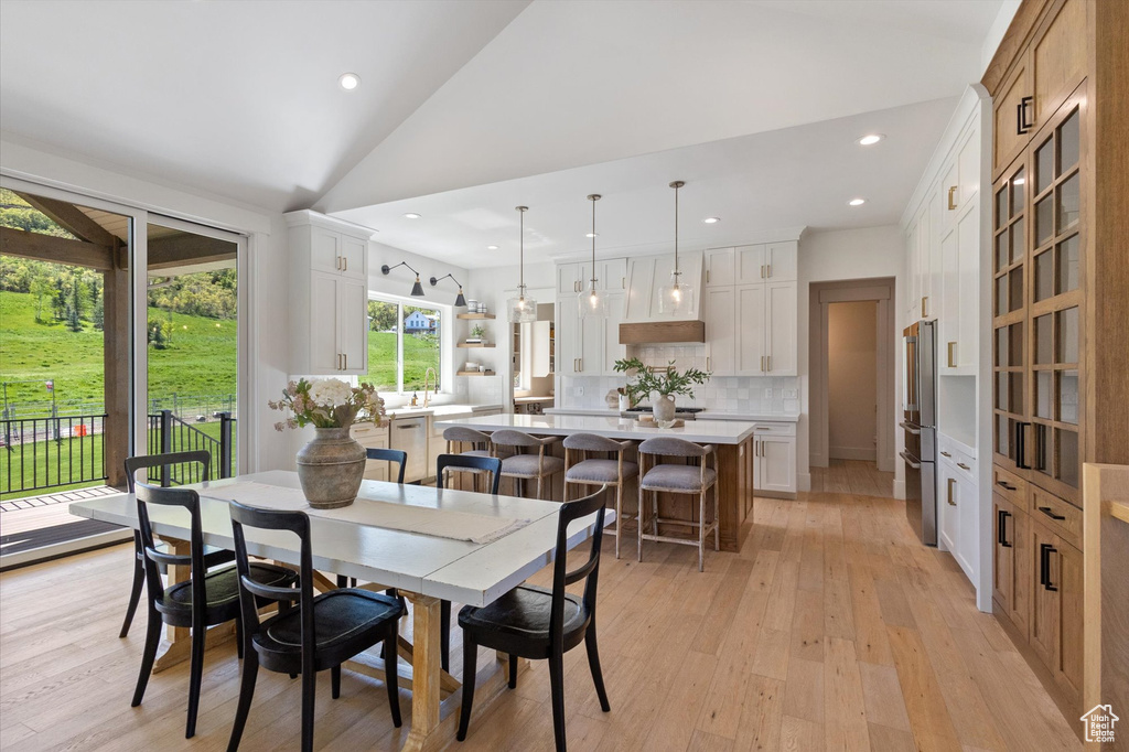 Dining space featuring light wood-type flooring, recessed lighting, and high vaulted ceiling