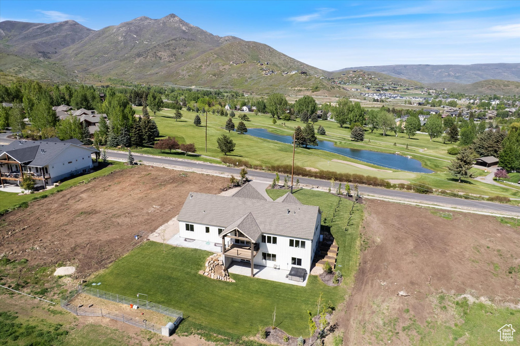 Aerial view of property and surrounding area featuring a water and mountain view