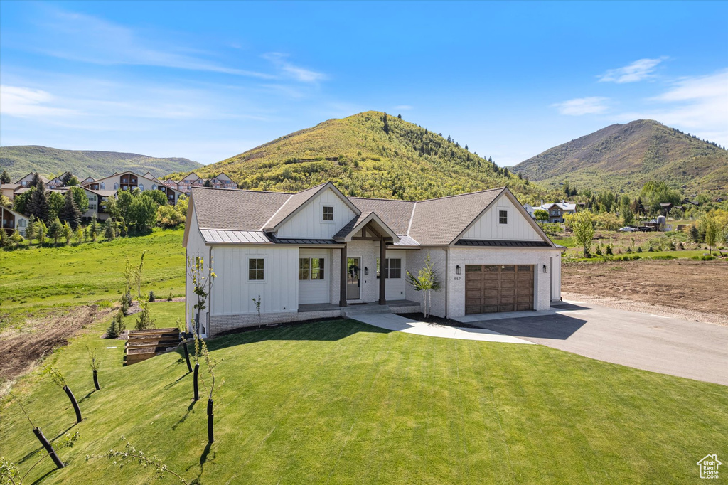 Modern farmhouse style home featuring board and batten siding, concrete driveway, an attached garage, and a front yard