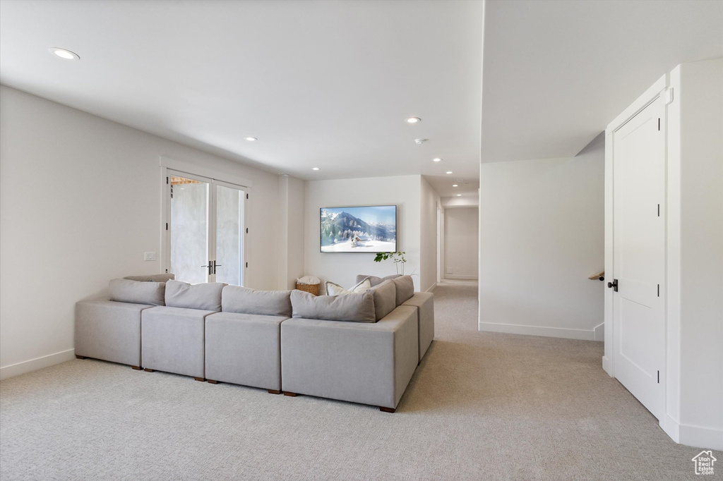 Living room with light carpet, recessed lighting, and baseboards